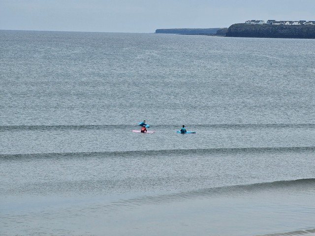 a trio of surfers having the chats while waiting for waves
